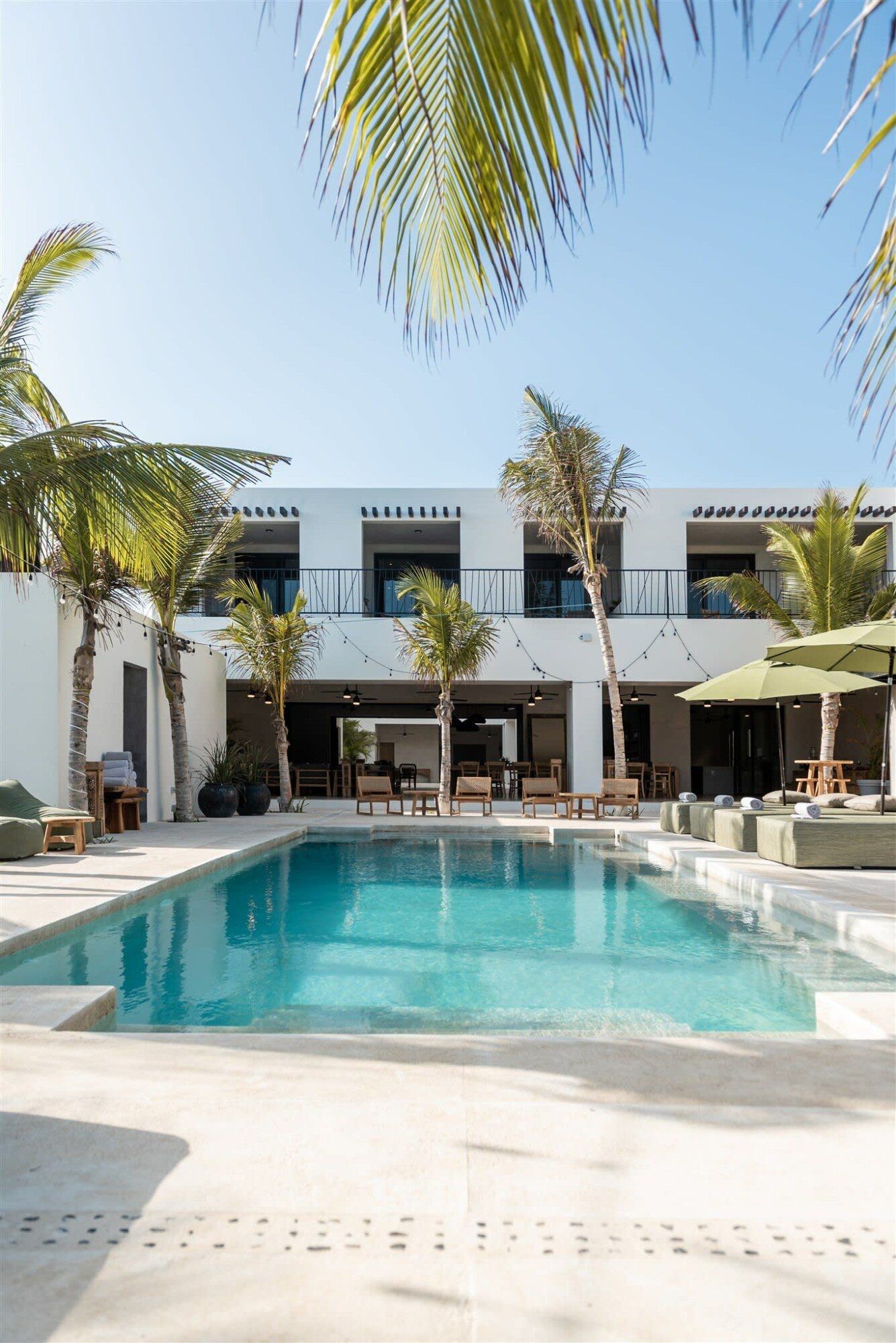Exterior of Hacienda Jaguar villa with pool and palm trees in Puerto Aventuras, Mexico