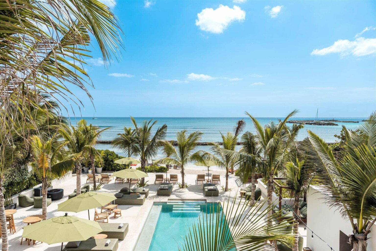 Rooftop pool terrace overlooking the ocean at Hacienda Jaguar in Puerto Aventuras, Riviera Maya
